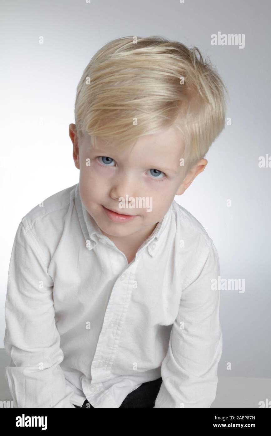 portrait of smiling face child. handsome little boy isolated on light gray studio. 8 years old kid,USA,06,Dec,2019 Stock Photo