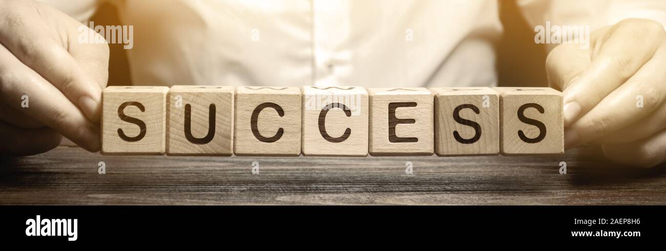 Wooden blocks with the word Success and businessman. Successful business concept. Achieving the goal, overcoming difficulties. The growth of profits a Stock Photo