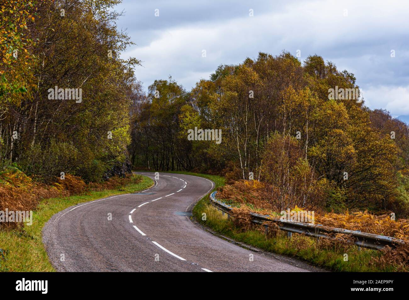 Bendy, country road in Scottish highlands with autumn coloured trees on