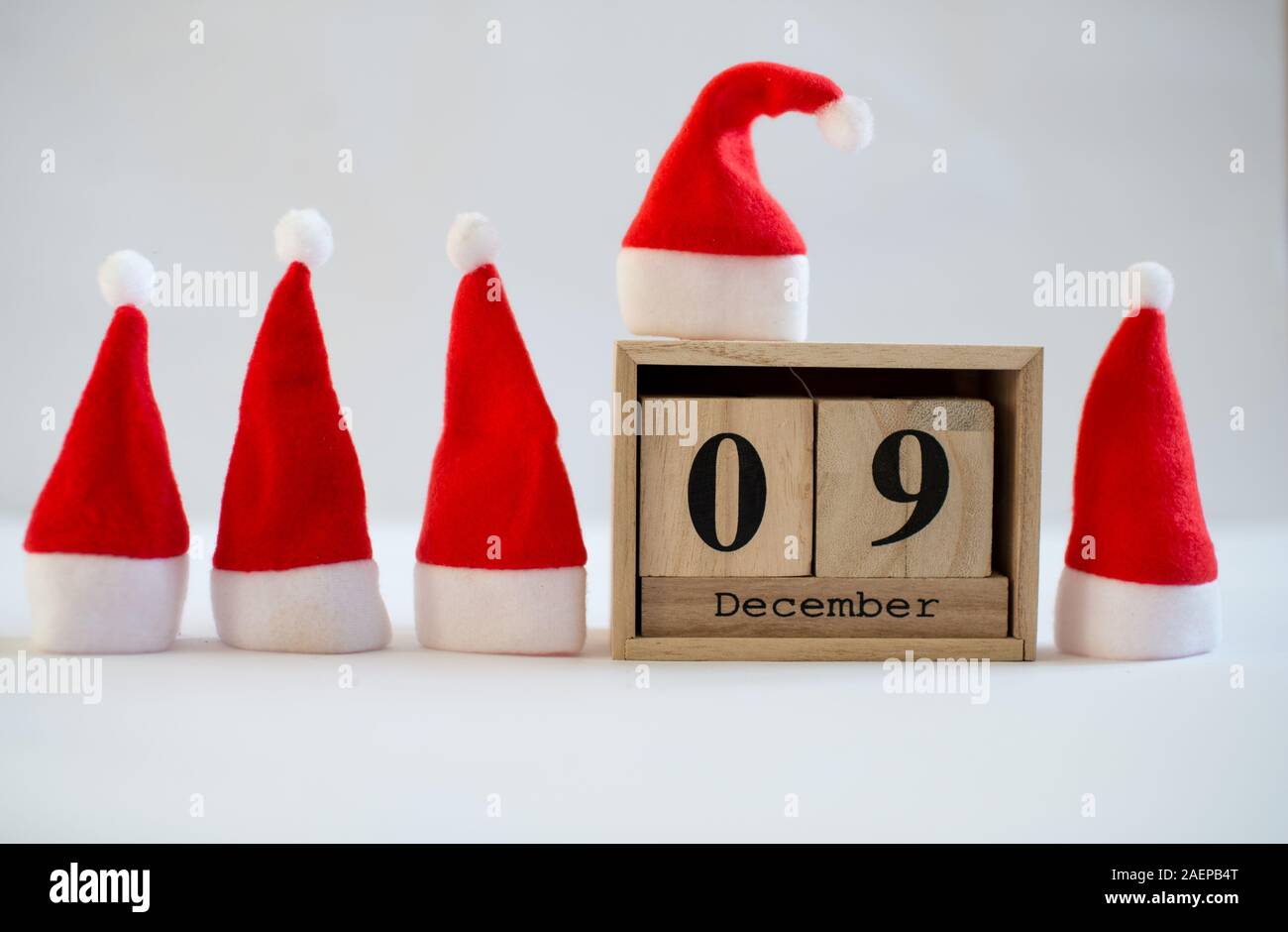 December 9999 Cube wooden calendar showing date on 9th December with small Santa hats ...