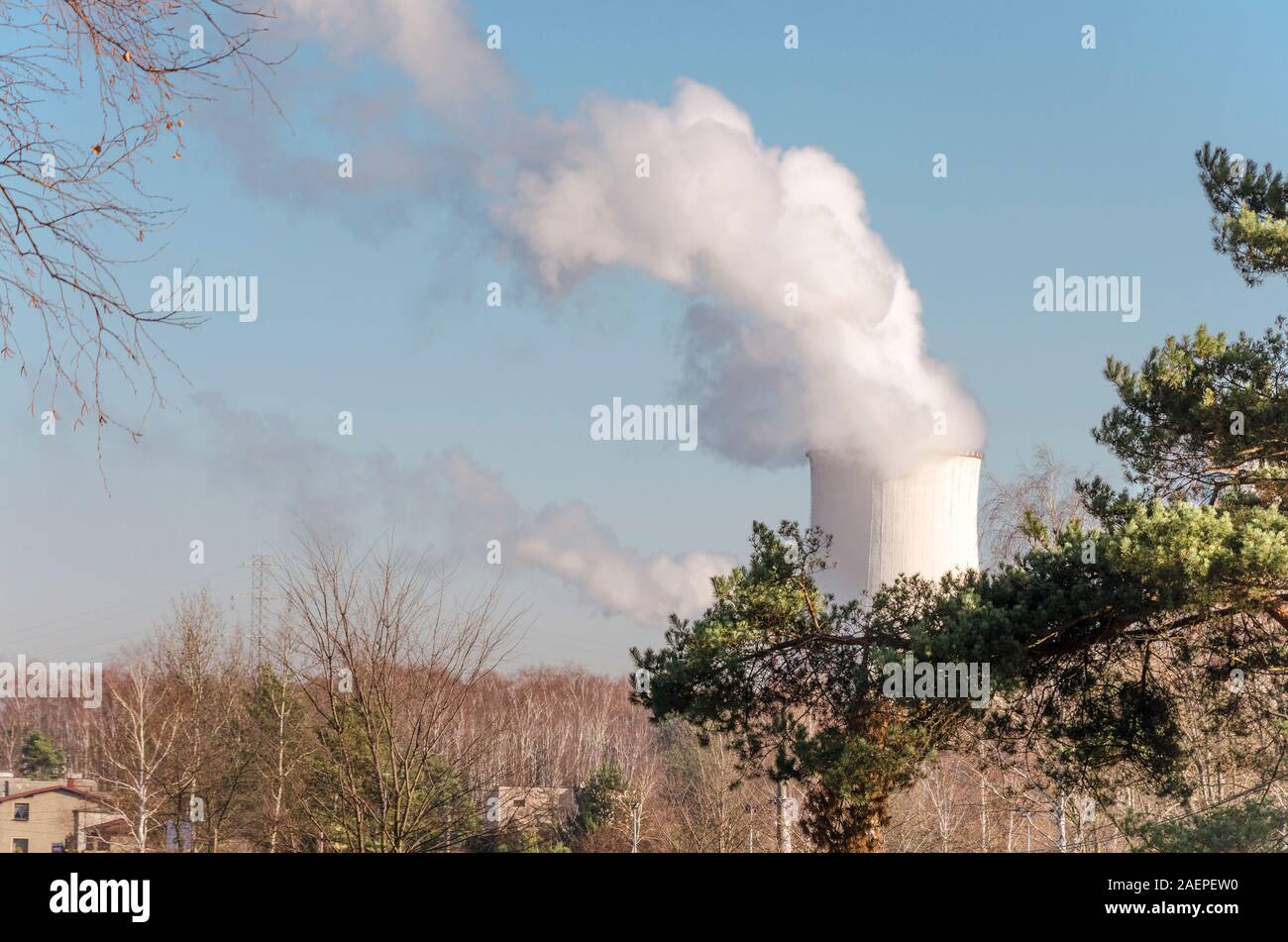 Power plant funnel emitting fumes and smoke near housing estate and