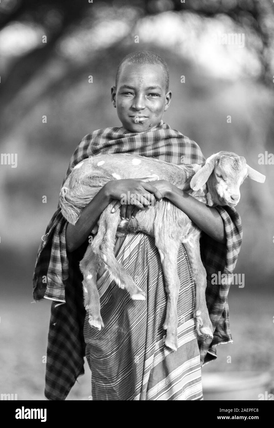 same, Tanzania, 4th June 2019: maasai boy with a baby goat Stock Photo