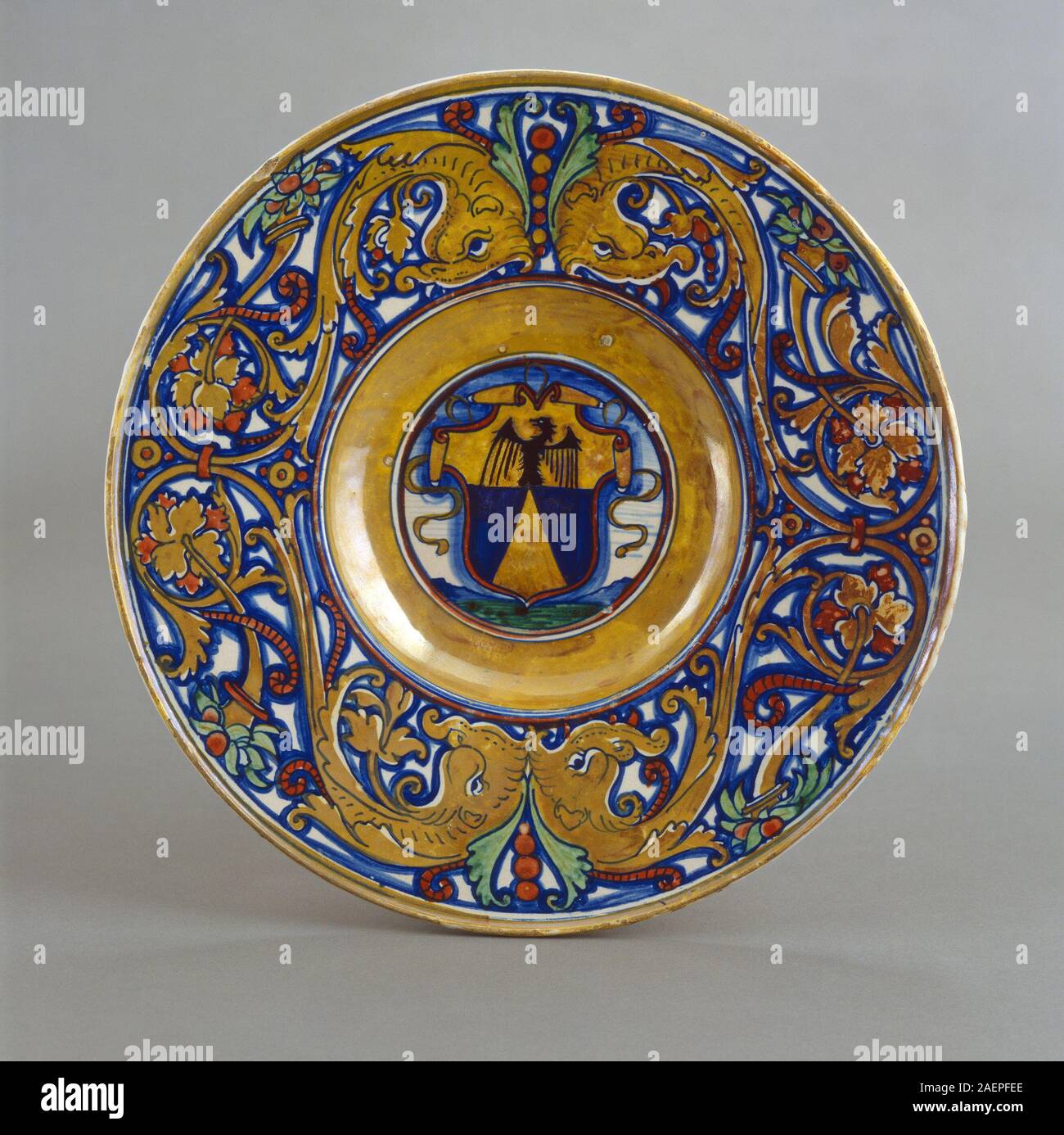 Workshop of Maestro Giorgio Andreoli of Gubbio, Plate with border of foliate scrollwork with dolphin heads and cornucopias; in the center, shield of arms of Vigerio of Savona, 1524, Workshop of Maestro Giorgio Andreoli of Gubbio, Plate with border of foliate scrollwork with dolphin heads and cornucopias; in the center, shield of arms of Vigerio of Savona, 1524, tin-glazed earthenware (maiolica), Widener Collection 1942.9.332 Stock Photo