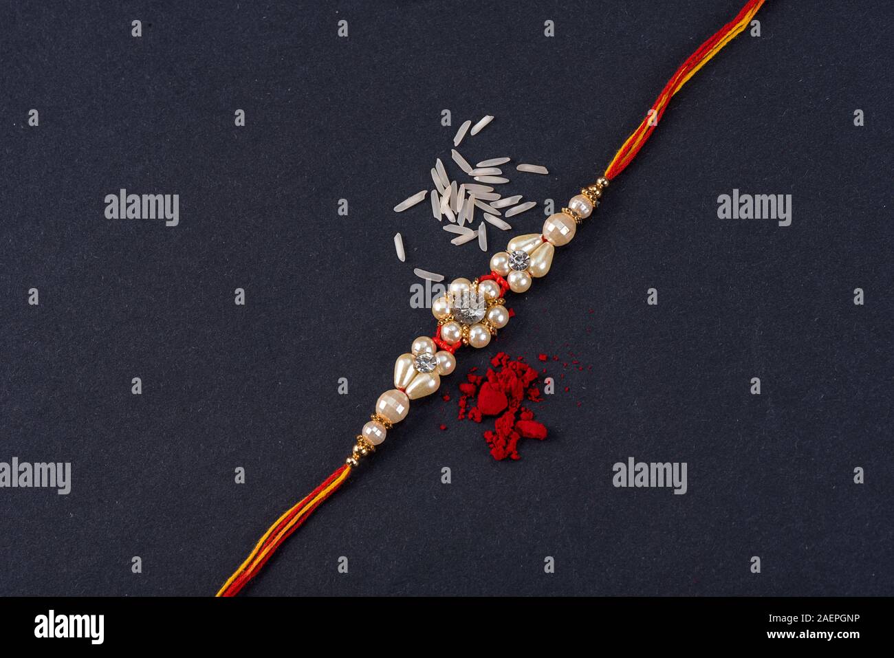 Raksha Bandhan : Rakhi with rice grains and kumkum on black background ...