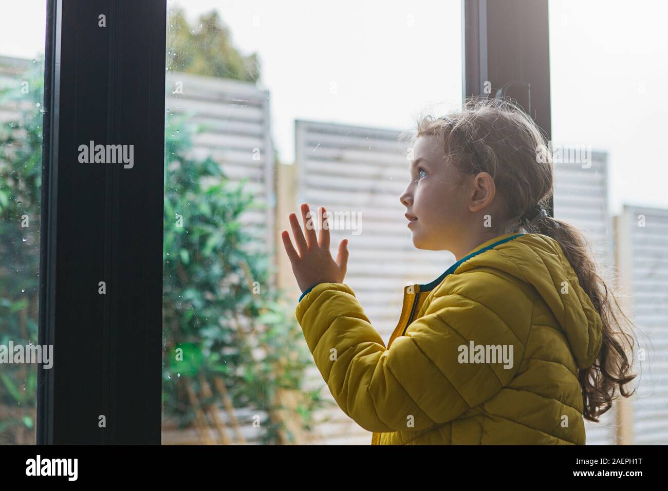 Young girl looking out of window Stock Photo