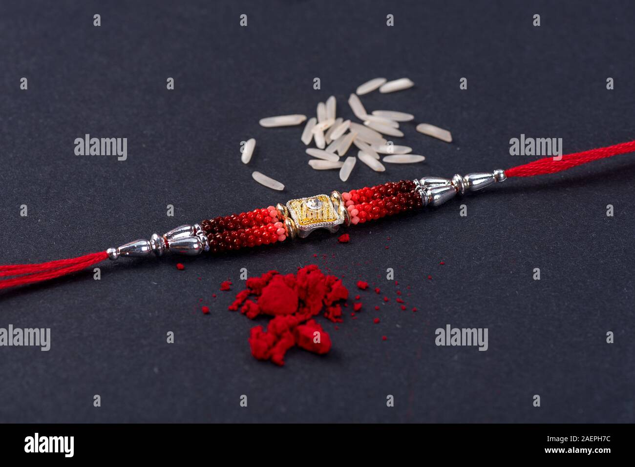 Raksha Bandhan : Rakhi with rice grains and kumkum on black background ...
