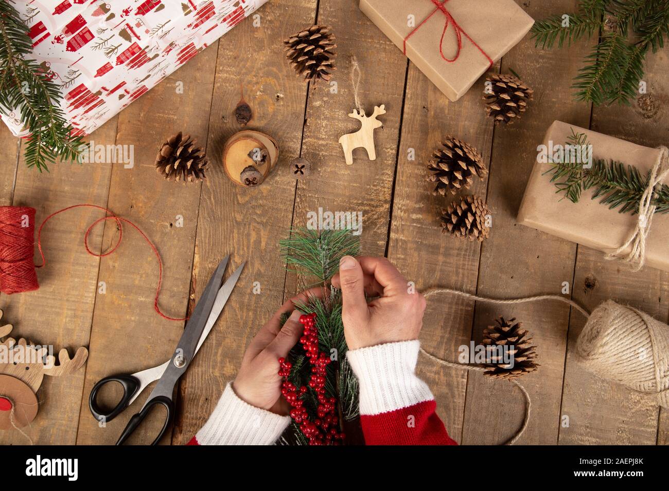 Man hands catching a Christmas bite on the vintage wooden work table. Christmas concept. Top view Stock Photo