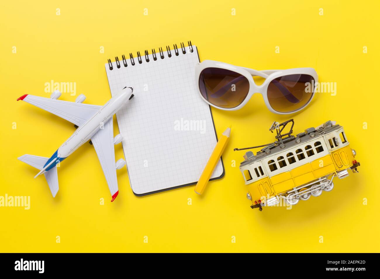 Travel concept with photos, airplane toy, tram and notepad. Top view flat lay with copy space Stock Photo