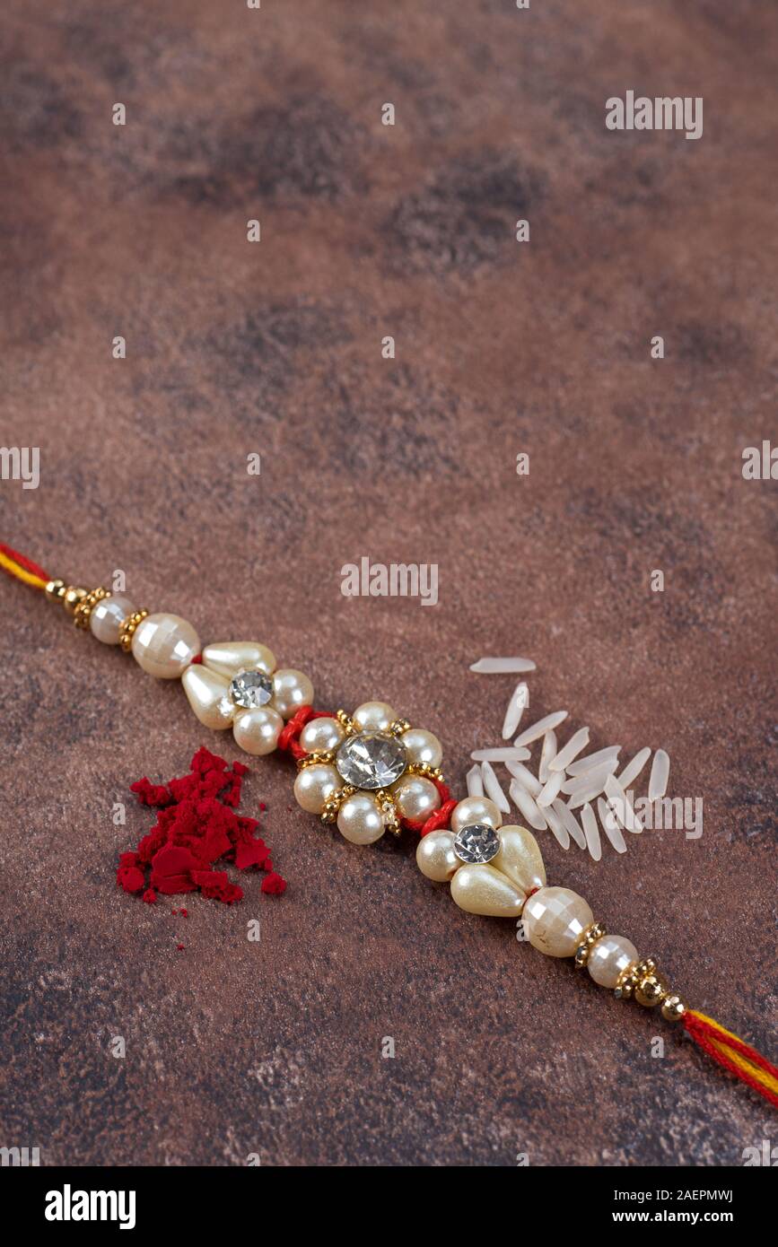 Raksha Bandhan : Rakhi with rice grains and kumkum on stone background ...