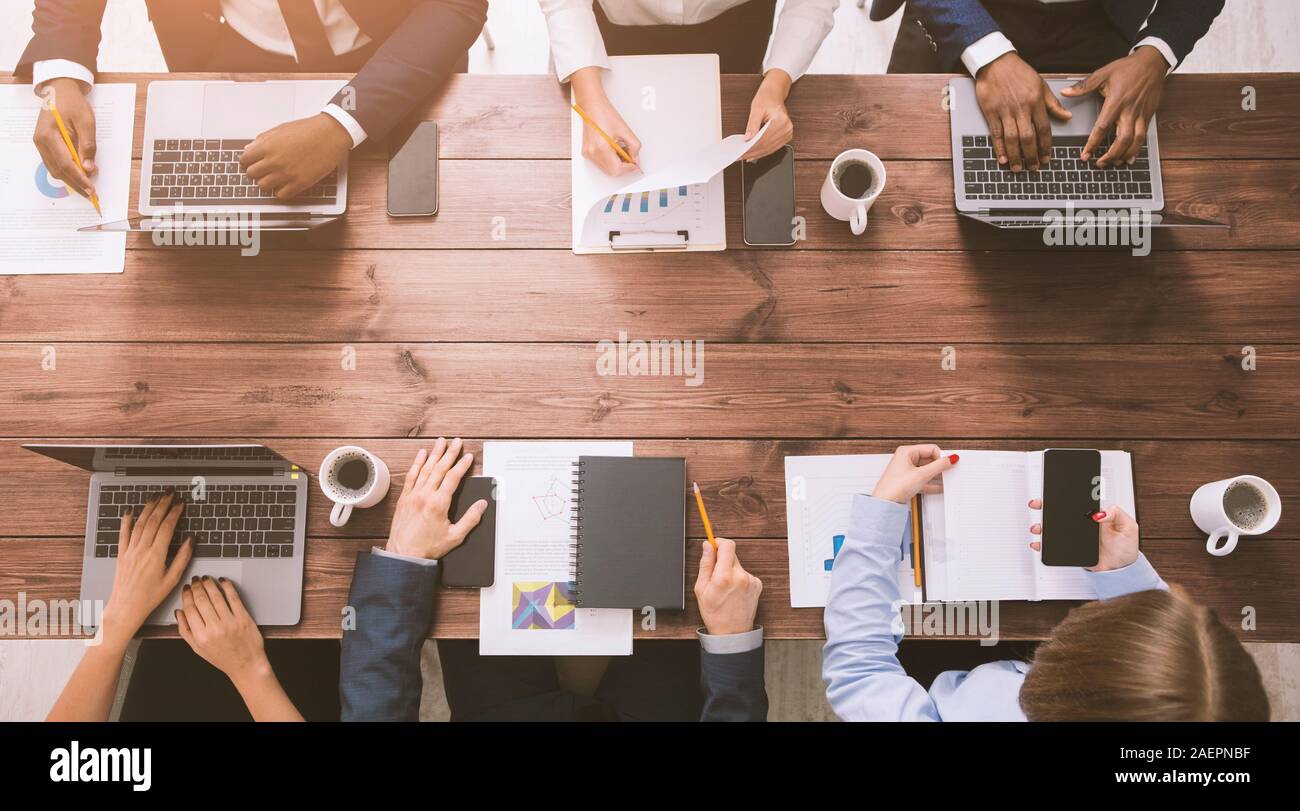Corporate team working at office, with gadgets and documents Stock Photo