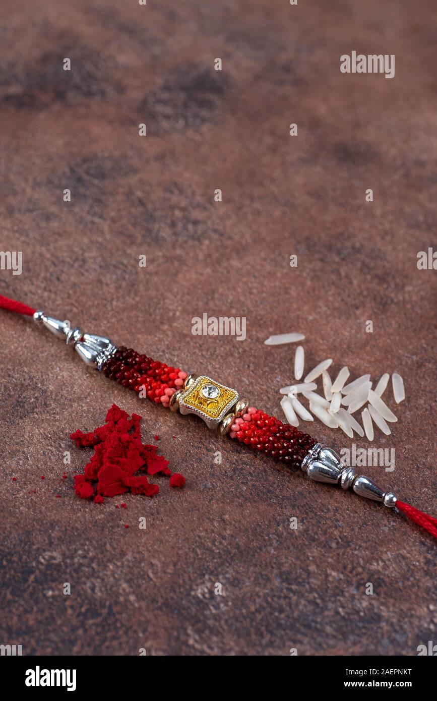 Raksha Bandhan : Rakhi with rice grains and kumkum on stone background ...