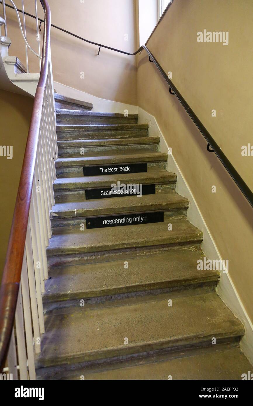 The back stairs or servants stairs with a sign saying 'the best back staircase is for descending only', at Attingham Park, Shropshire, England, UK Stock Photo