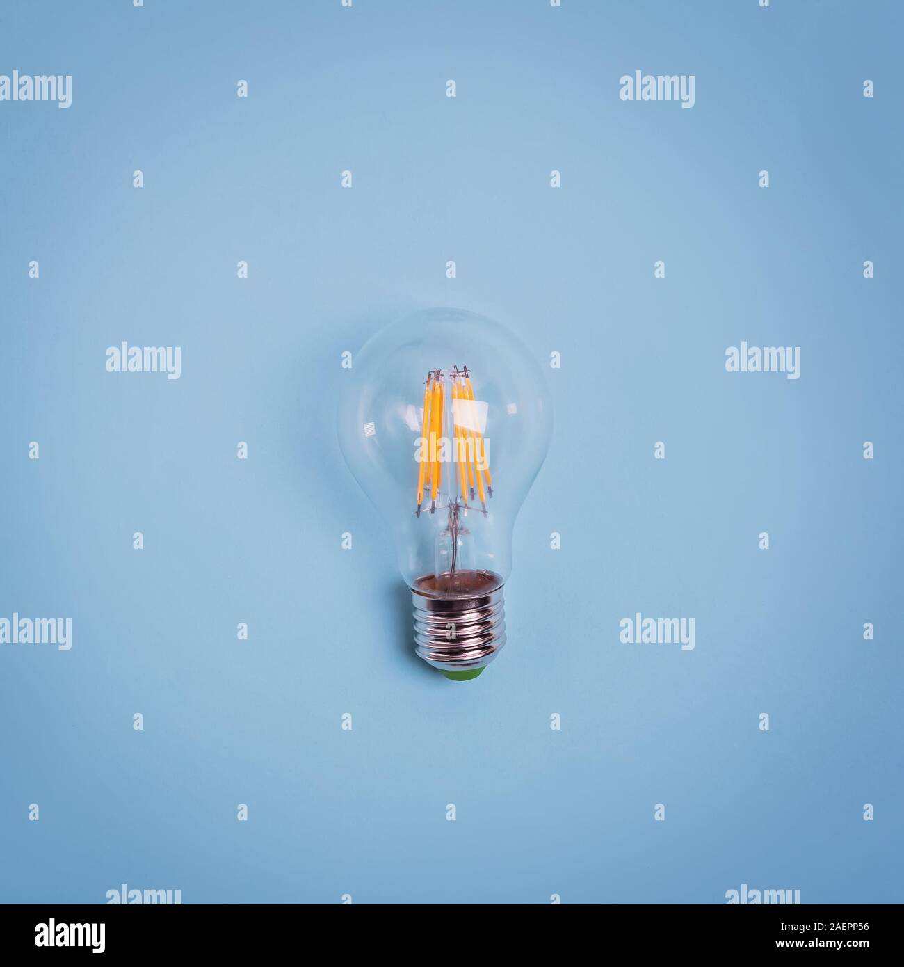 Retro electric light bulb isolated on blue background. Stock Photo