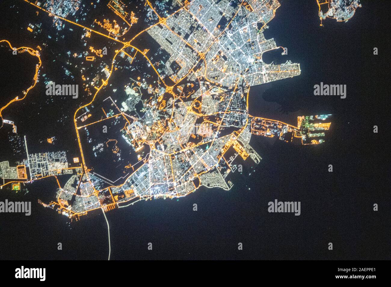 A nighttime view of Dammam, Saudi Arabia as seem from the International Space Station orbiting 262 miles above the port city December 3, 2019 in Earth Orbit. The fork-like structure at right is the King Abdulaziz Seaport. Stock Photo