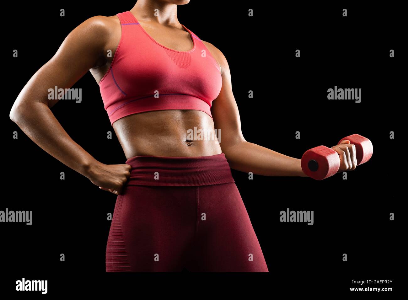 Strong black woman pumping iron over black background Stock Photo