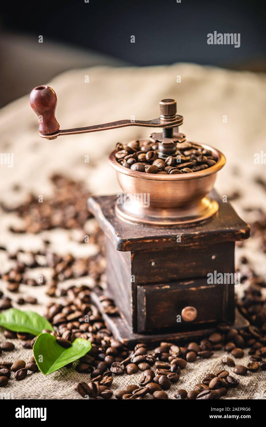 Wooden vintage hand coffee grinder and cup on a pile of brown coffee beans.  Grinding fragrant freshly roasted coffee Stock Photo - Alamy