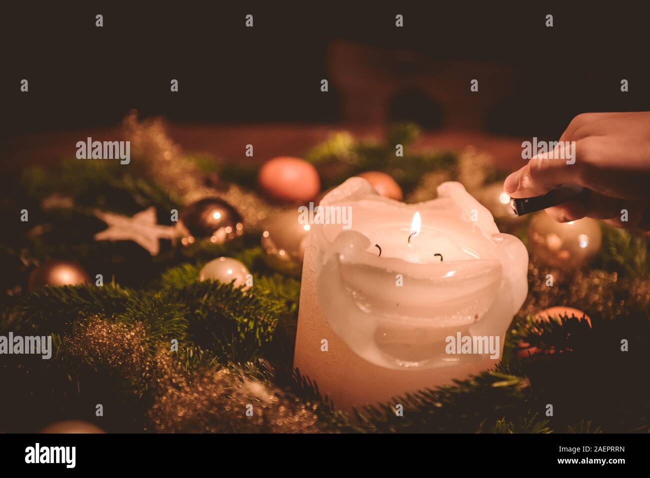 lighting the candle on the Advent wreath during christmas time Stock Photo