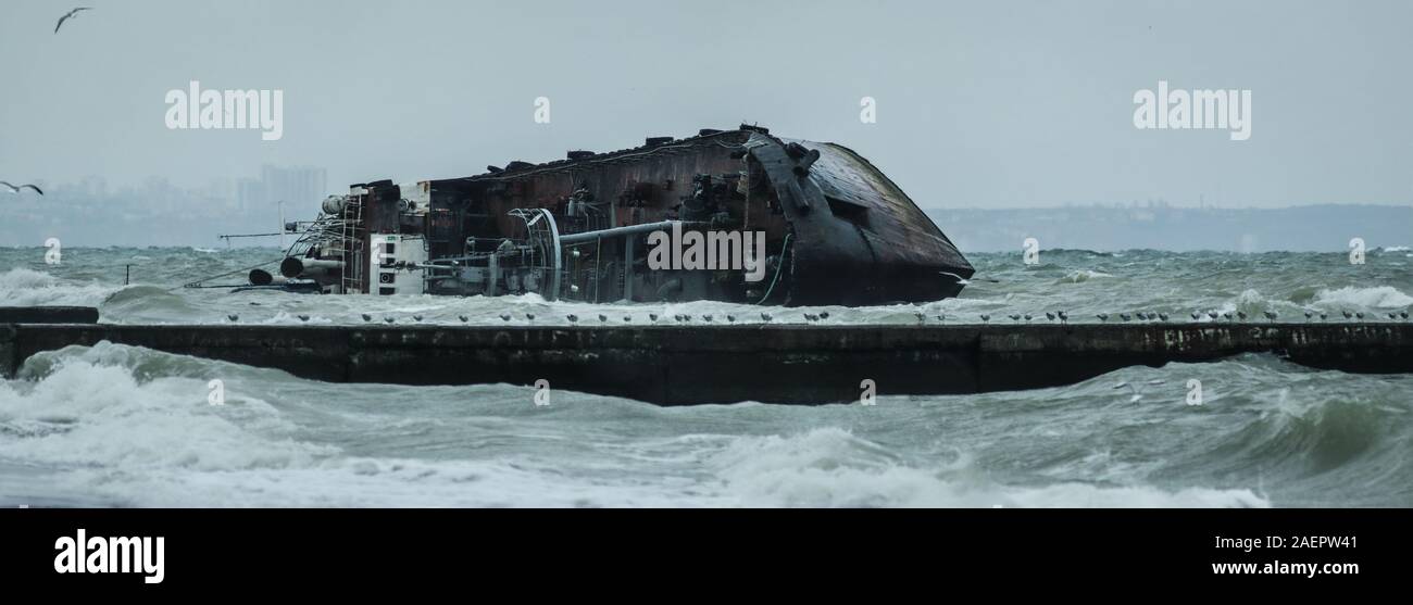 The wreck of the tanker  on the Odessa beach. Ecological disaster - oil spill on city beaches as a result of a shipwreck. Selective focus Stock Photo