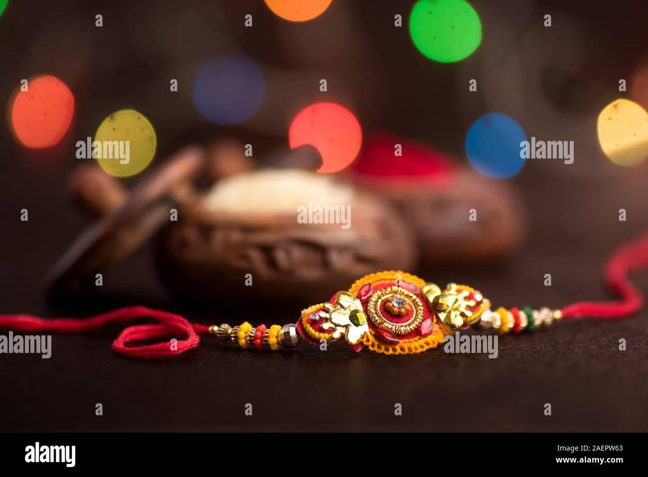 Raksha Bandhan background with an elegant Rakhi, Rice Grains and Kumkum ...