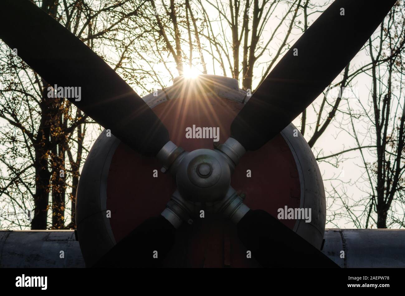 propeller of a vintage airplane in the rays of the evening sunset close ...
