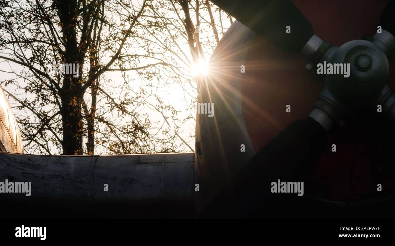 propeller of a vintage airplane in the rays of the evening sunset close ...