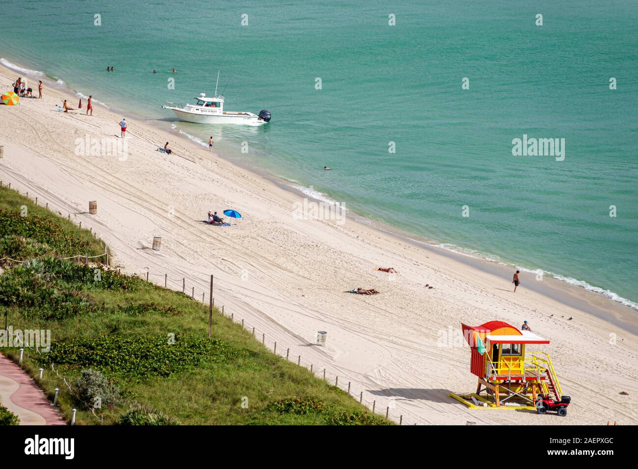 Miami Beach Florida,North Beach,shore,sand,water surf,lifeguard stand,dune,sunbathers,boat,hydrographic survey boat,coming ashore,public,Atlantic Ocea Stock Photo