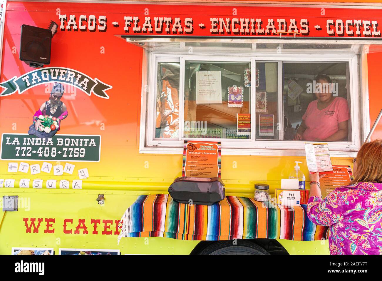 Indiantown Florida,food truck,small business,Mexican food,tacos,flautas,enchiladas,taqueria,vendor window,Hispanic,woman,ordering,FL191110039 Stock Photo