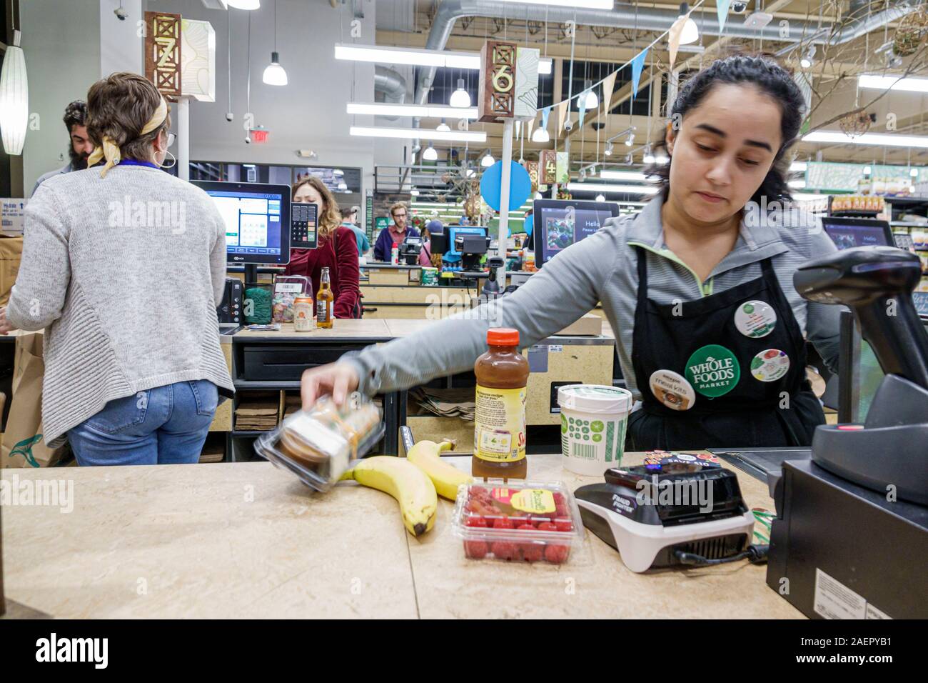 Orlando Florida,Whole Foods Market,supermarket grocery store,organic grocer,inside interior,interior inside,cashier,working,checkout,Hispanic Latin La Stock Photo