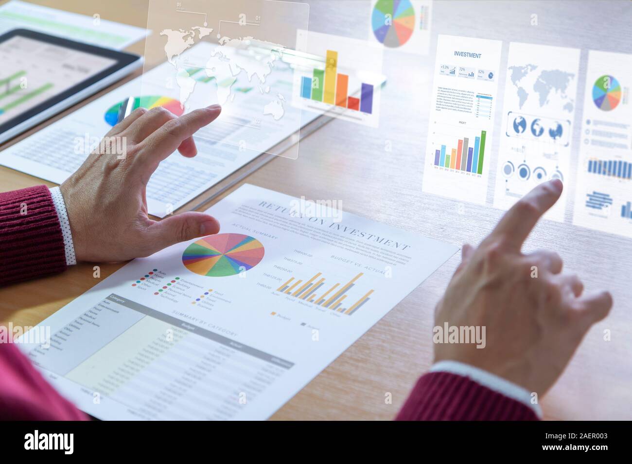 Businessman interacts with augmented reality graphics while deeply reviewing a financial report for a return on investment or investment risk analysis Stock Photo