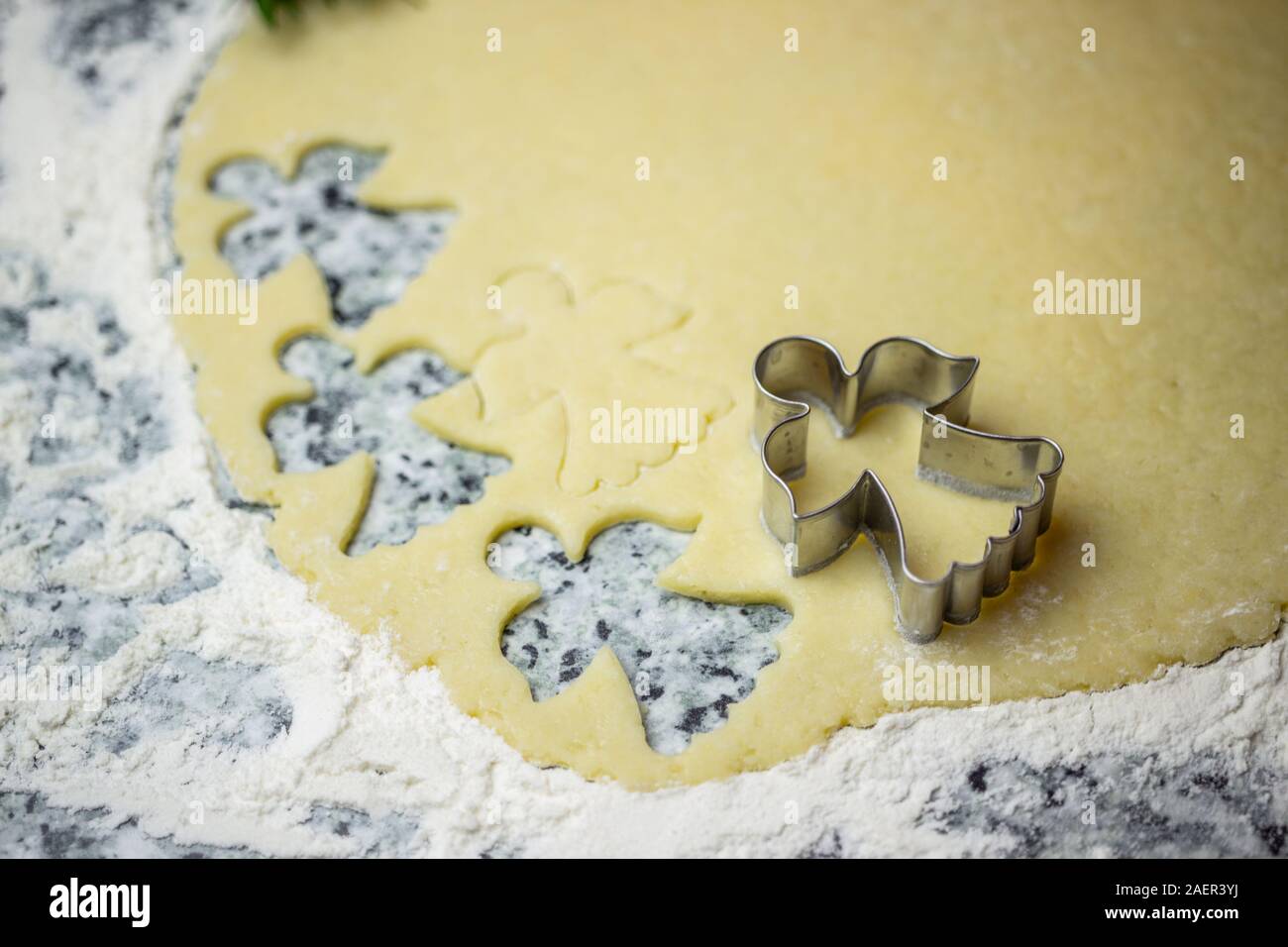 Christmas bakery cookie dough and cookie cutter. Top view christmas biscuit dough and green spruce decoration with copy space for text. Stock Photo