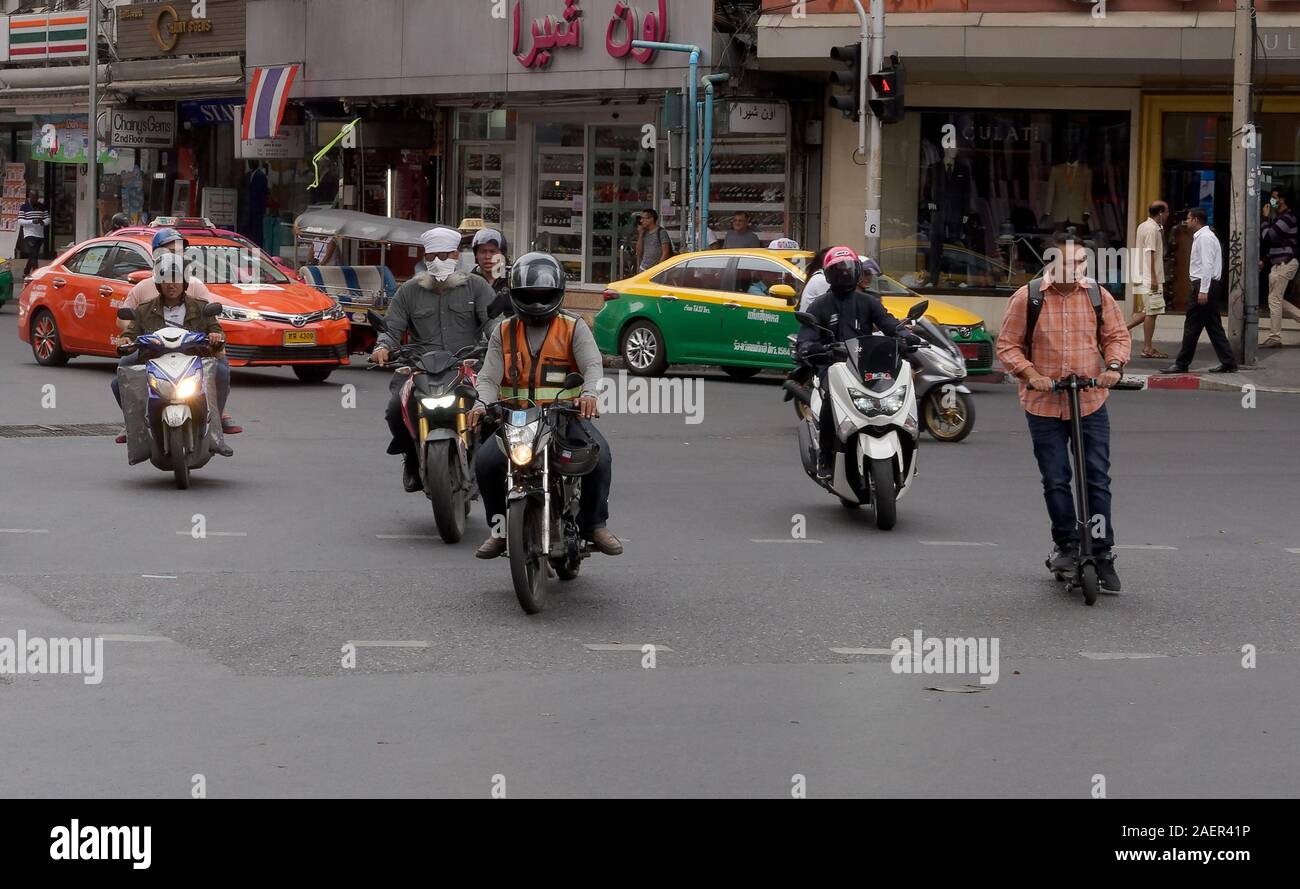 An electric scooter rider defies road safety logic on a busy junction