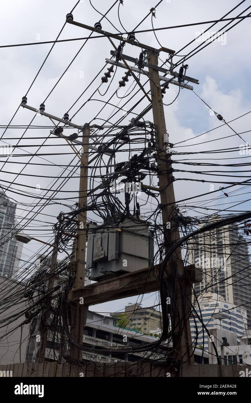 No one will ever call the overhead power cables in Bangkok well managed. Stock Photo