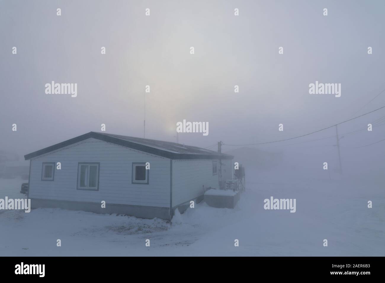 Blizzard conditions in Arviat, Nunavut Canada during December month.  House almost completely gone under winter conditions in the Canadian Arctic Stock Photo
