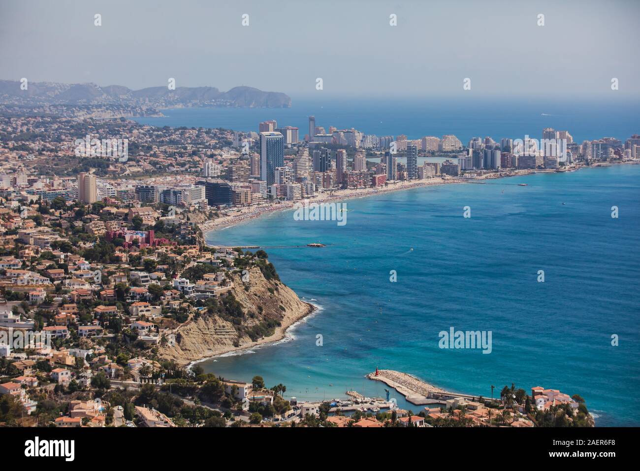 Beautiful super wide-angle aerial view of Calpe, Calp, Spain with harbor and skyline, Penon de Ifach mountain, beach and scenery beyond the city, seen Stock Photo