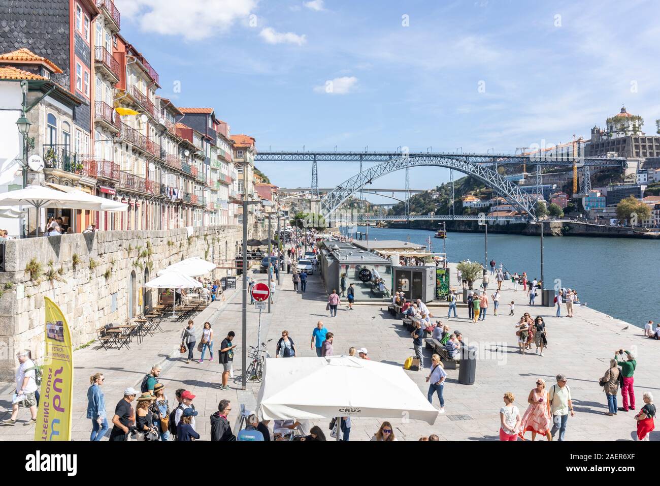 Porto, north bank of the Douro River looking eastward towards the Luis I bridge.  Tourists queue to take boat rides along the Douro river Stock Photo