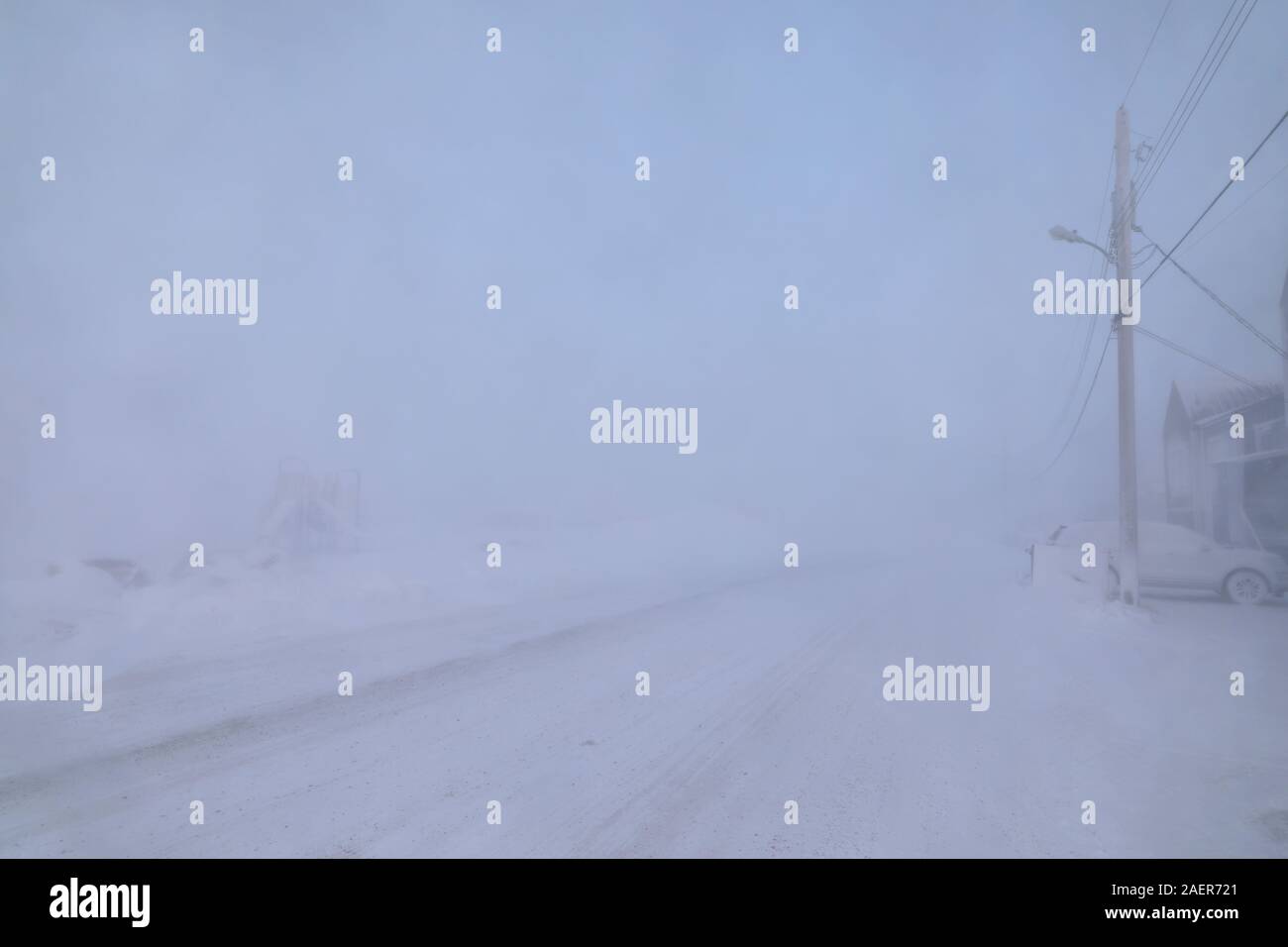 Road and buildings disappearing under blizzard or winter conditions in the Canadian Arctic in the community of Arviat, Nunavut Canada Stock Photo