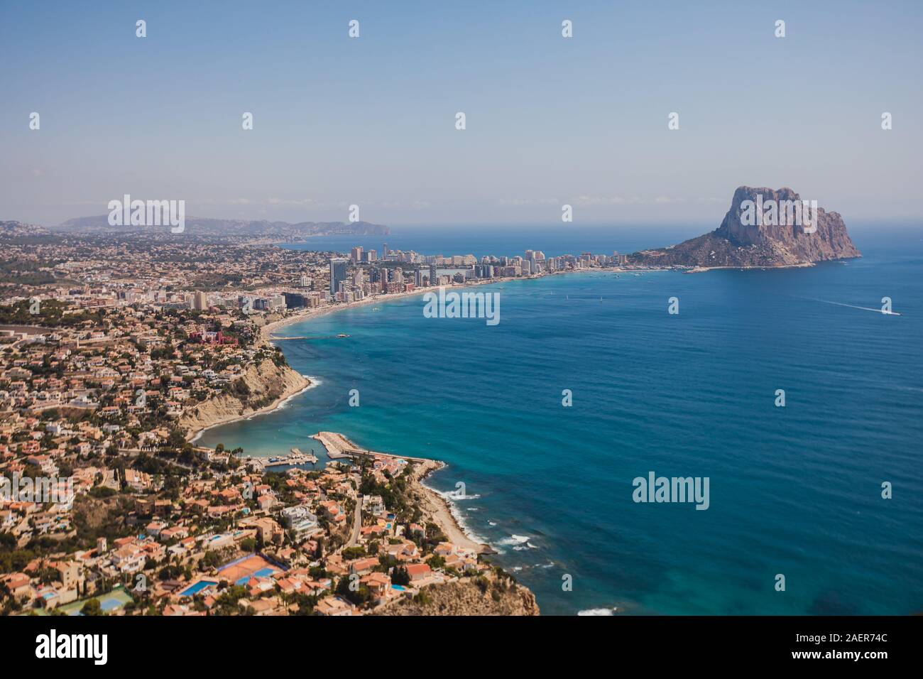 Beautiful super wide-angle aerial view of Calpe, Calp, Spain with harbor and skyline, Penon de Ifach mountain, beach and scenery beyond the city, seen Stock Photo