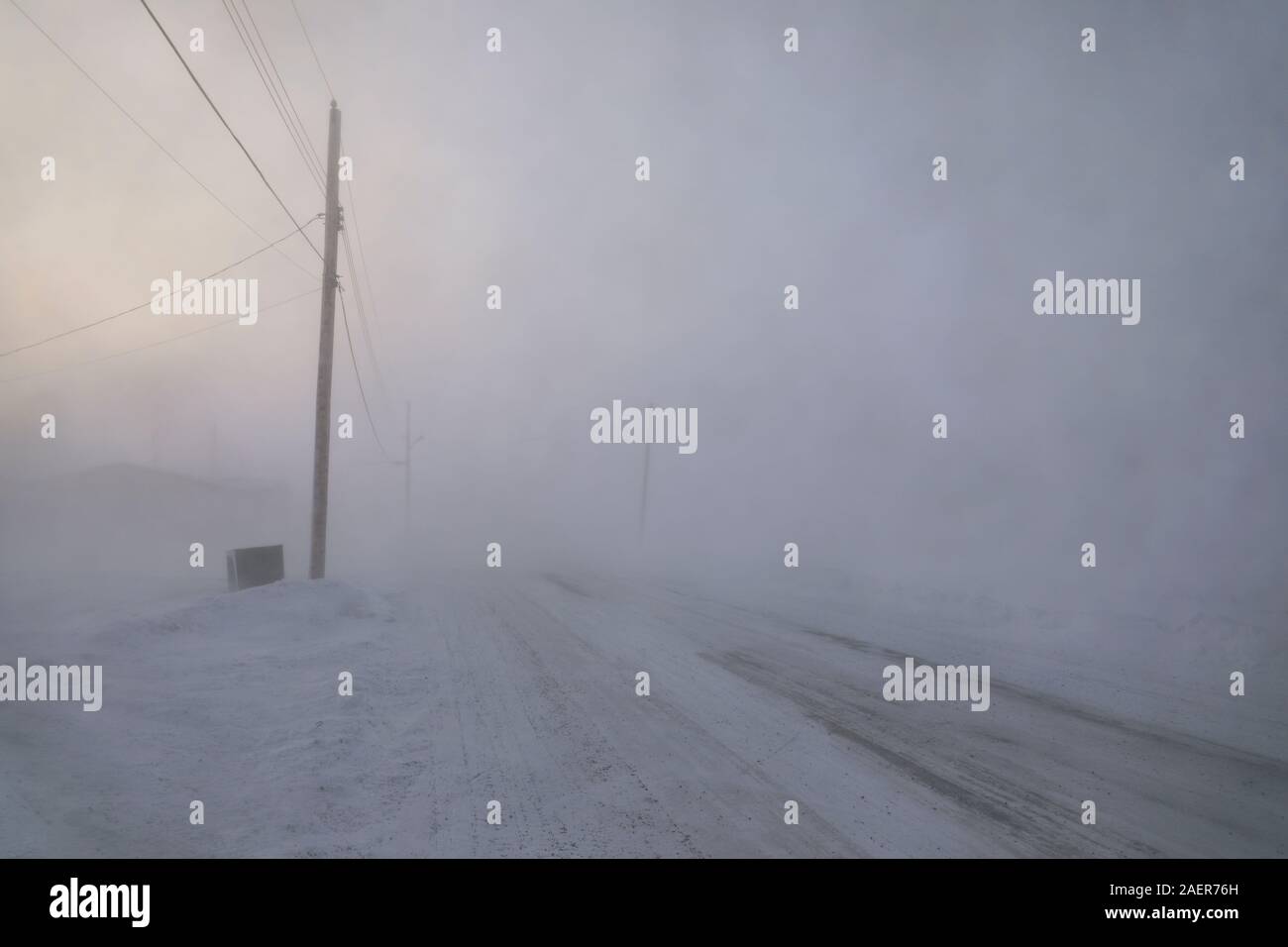 Road and buildings disappearing under blizzard or winter conditions in the Canadian Arctic in the community of Arviat, Nunavut Canada Stock Photo