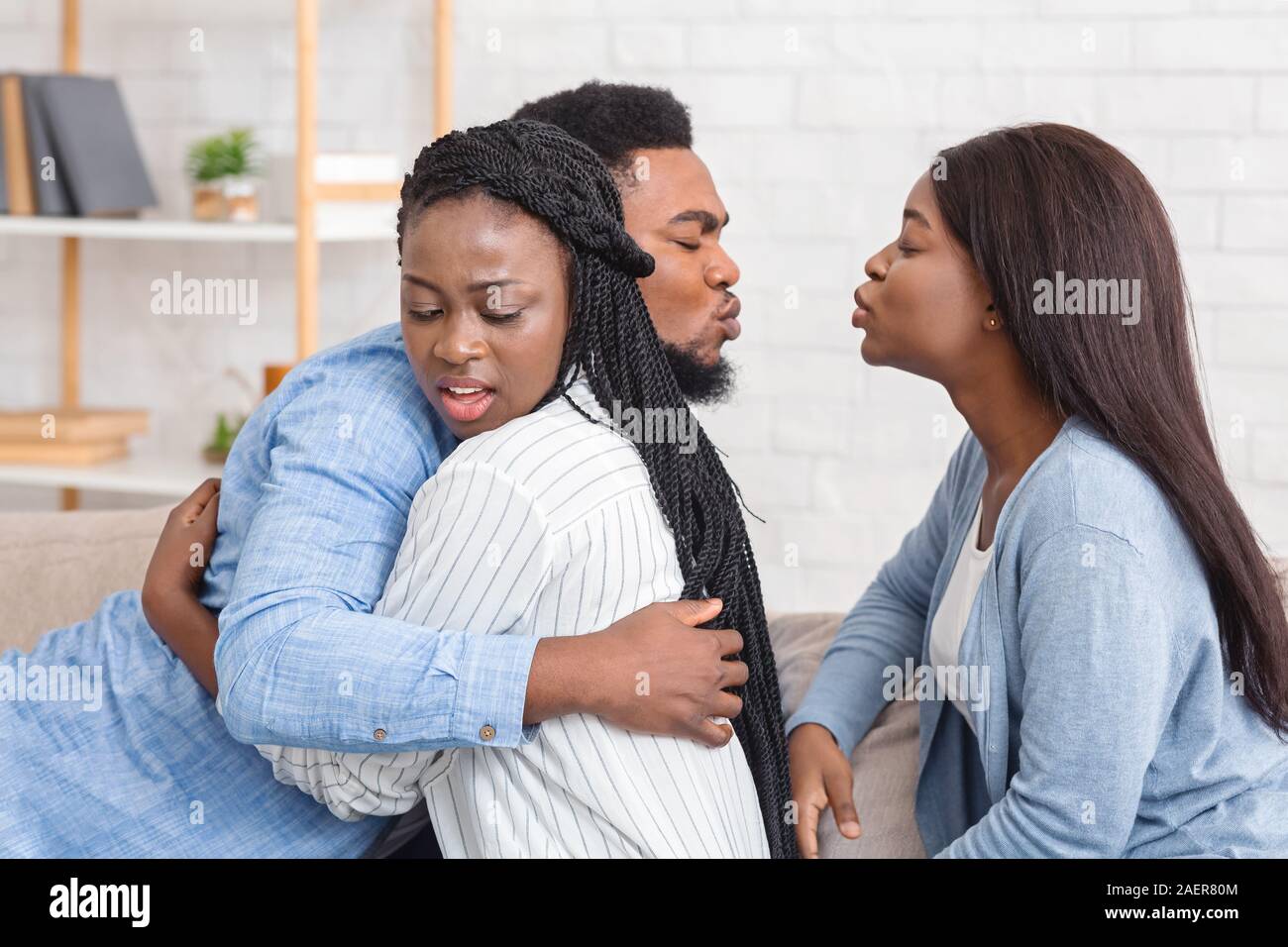 Cheating Afro Man Kissing Another Woman While Hugging With His Wife Stock Photo