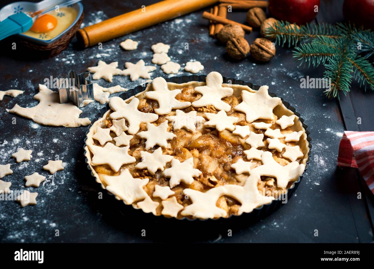 Festive decorated Apple pie in making on a festive decorated table Stock Photo
