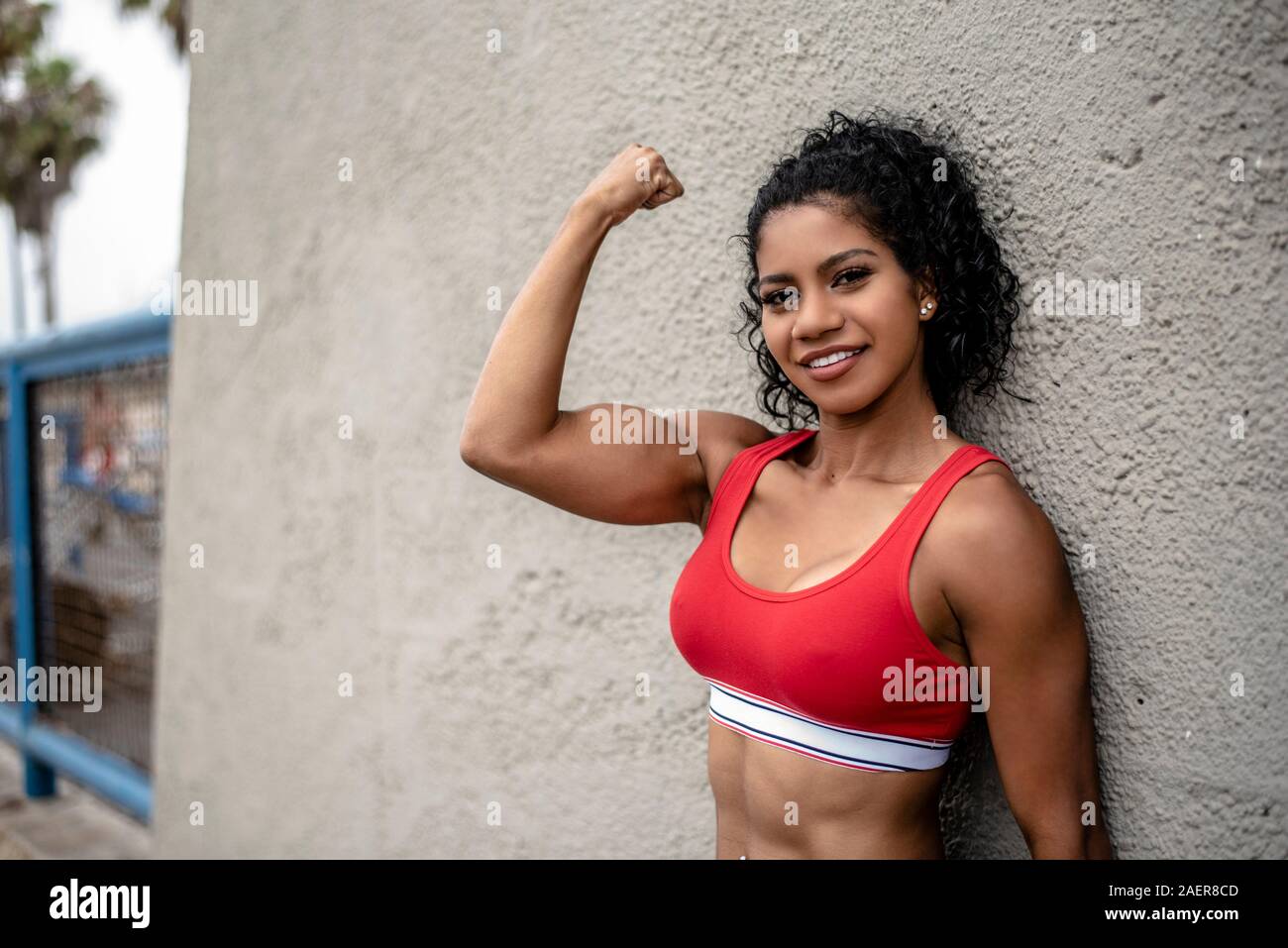 Female fitness model flexes her arm Stock Photo