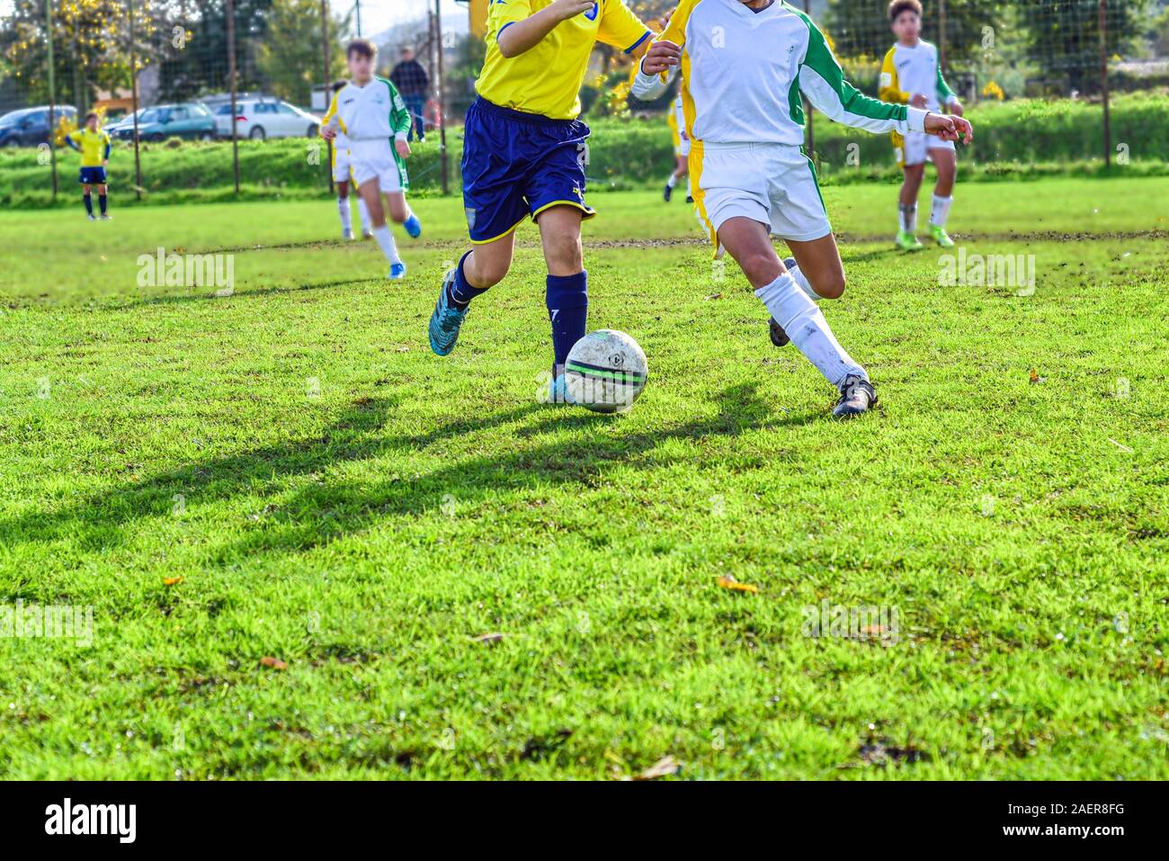 two young football players. Children play a soccer game. Legs in action with a ball. Stock Photo