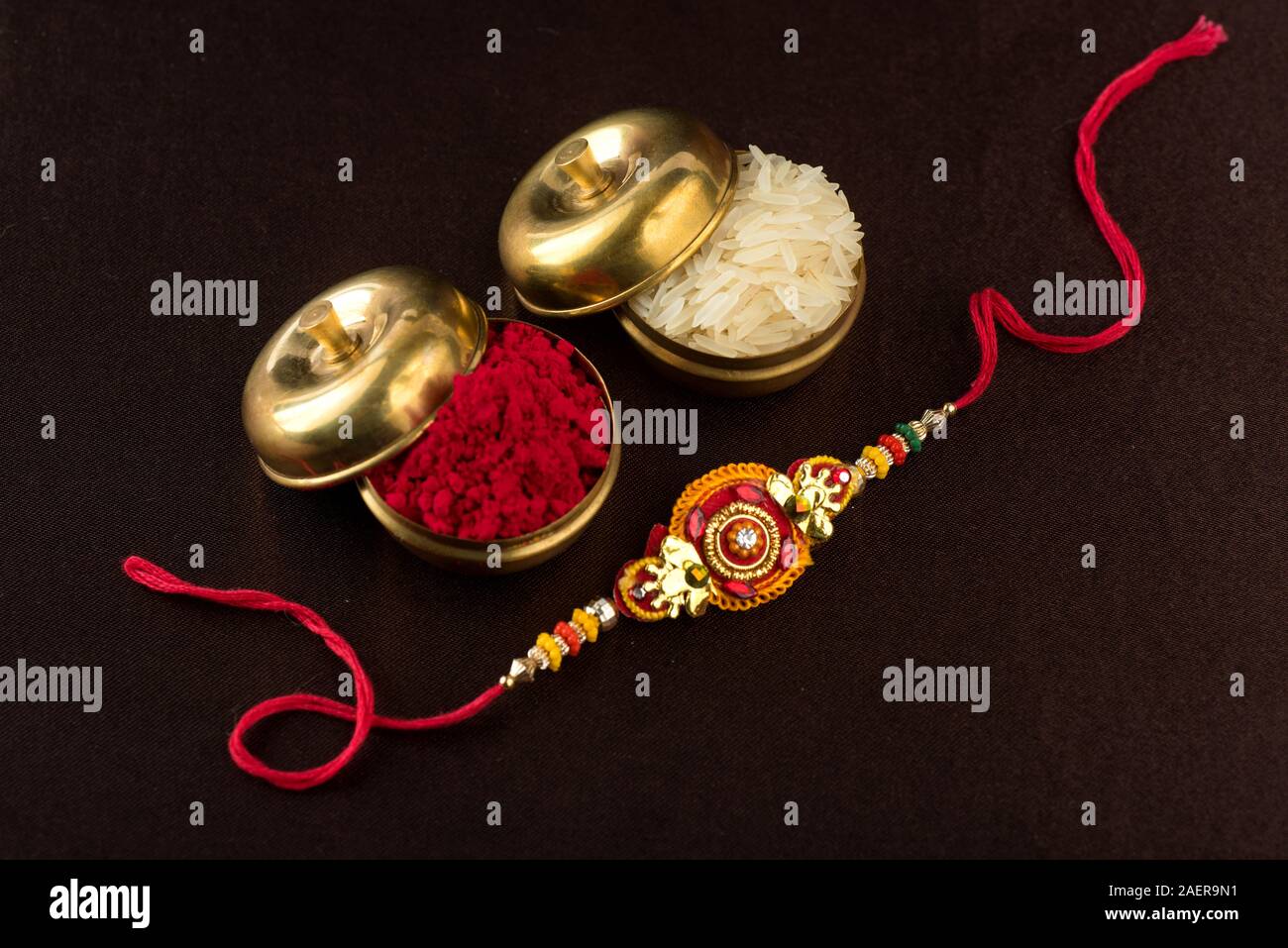 Raksha Bandhan background with an elegant Rakhi, Rice Grains and Kumkum ...