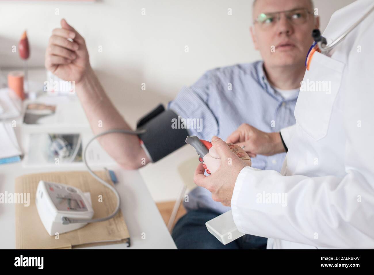 Cardiology consultation.Doctor briefs middle-aged patient on model of human heart Stock Photo