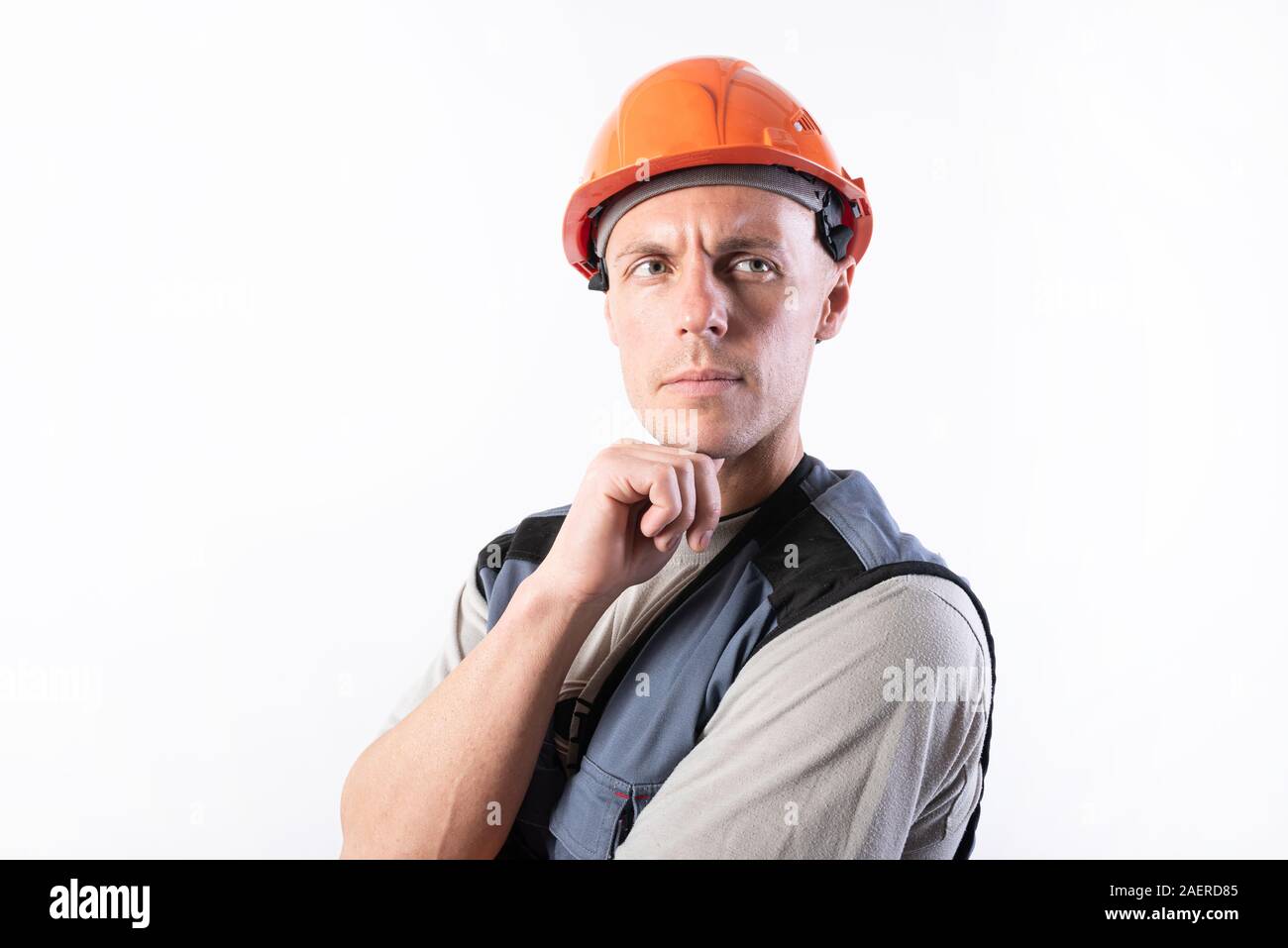 The builder thought. In work clothes and hard hat. Stock Photo