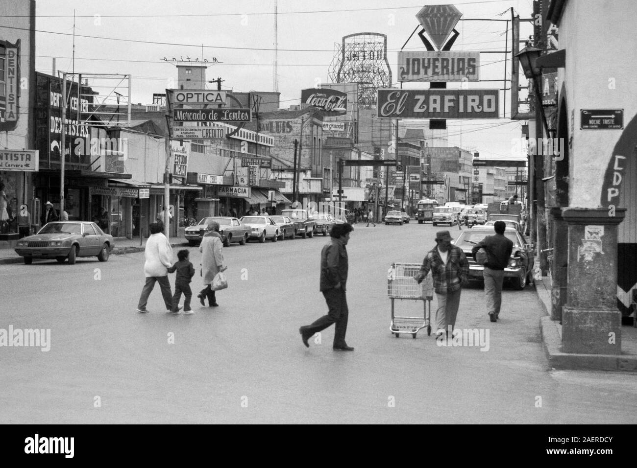 Ciudad Juarez, Chihuahua, Mexico - February, 1986:  Archival view of buildings, stores, traffic, signs and street life on Calle 16 de Septiembre. Stock Photo