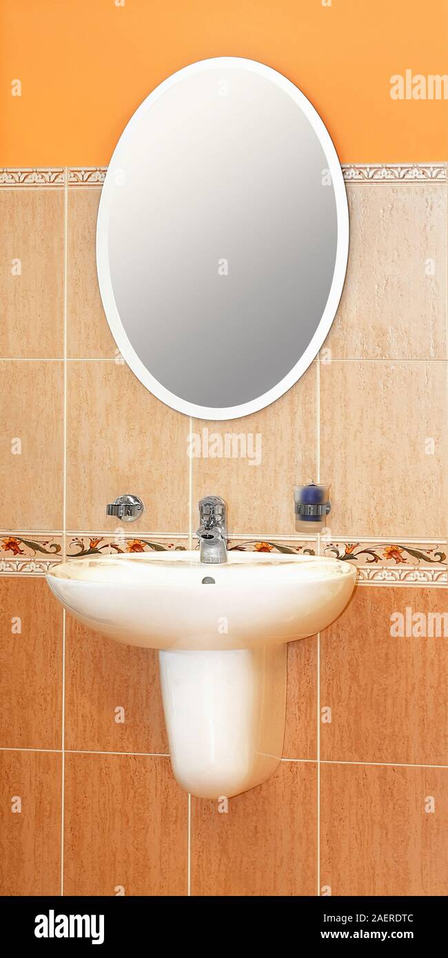 Modern wash basin and oval mirror in bathroom Stock Photo - Alamy