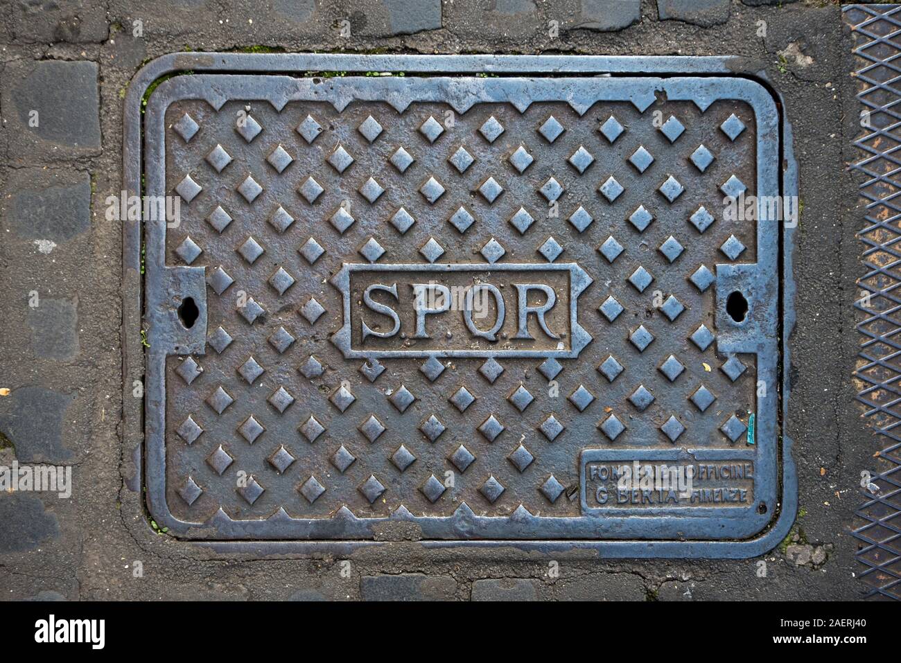 Manhole cover stamped with SPQR - Senātus Populusque Rōmānus in Rome, Italy. Stock Photo