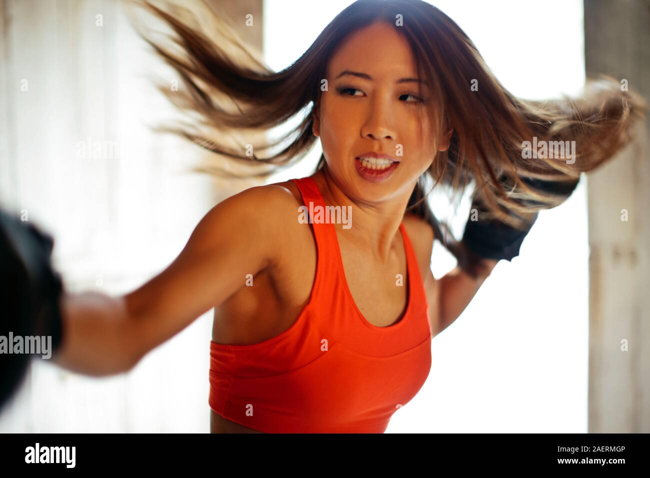 Tough young woman practices boxing. Stock Photo