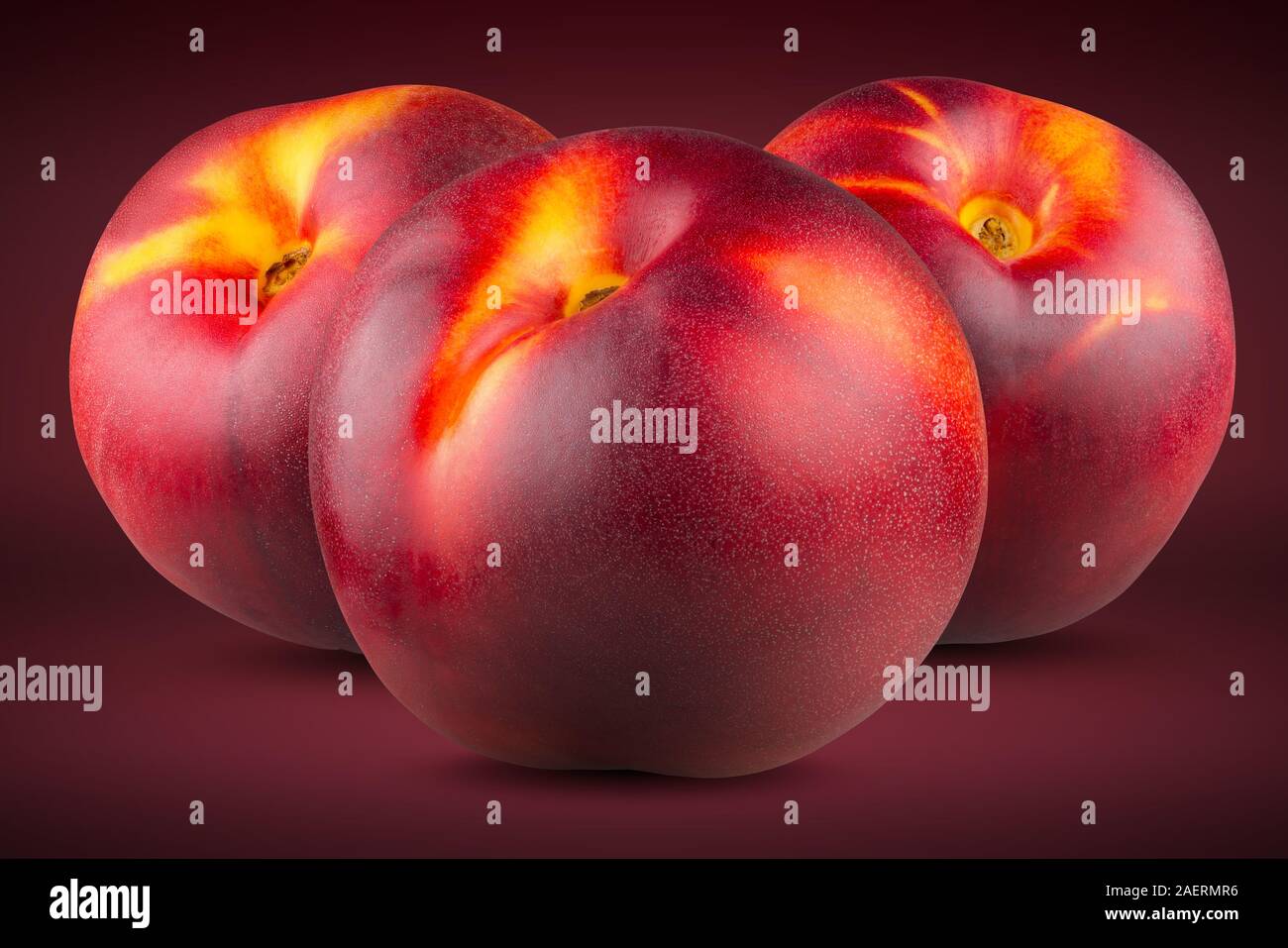 Three ripe peaches on a red(scarlet) background. Full depth of field ...